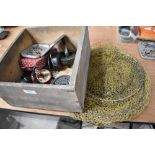 A wooden box containing mixed fishing tackle including reels,flies and a keep net.