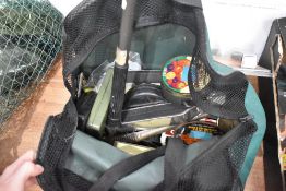 A fishing bag containing tins and tackle and a large landing net.