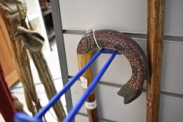 A walking stick with carved fish handle