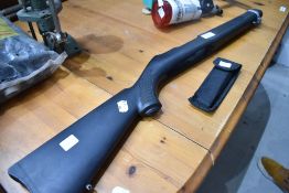 A Rugger 10/22 black synthetic stock with barrel band and folding saw knife