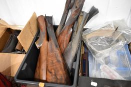 A selection of stripped gunstocks, springs, clay pigeons and gun oil.