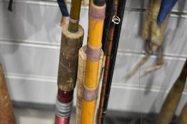 A selection of vintage fishing rods with fly reel and a landing net