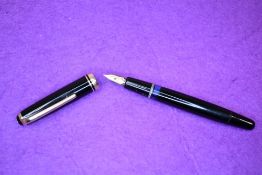 A Montblanc 254 fountain pen piston fill in black with gold trim having a Montblanc 14k nib.