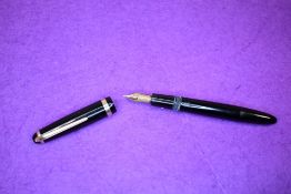 A Montblanc button fill fountain pen in black with gold trim, having a Montblanc 6 nib. Approx 13.