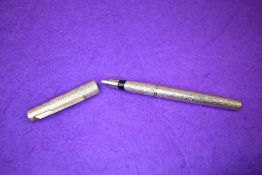 A Parker 105 cartridge fountain pen in bark effect rolled gold. Approx 13.2cm