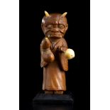 A WOOD, IVORY AND HORN OKIMONO OF A ONI DISGUISED AS A MONKJapan, Meiji period