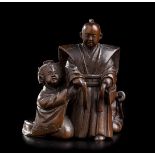 A WOOD NETSUKE WITH A SAMURAI AND TWO WOMENJapan, second half of the 19th century