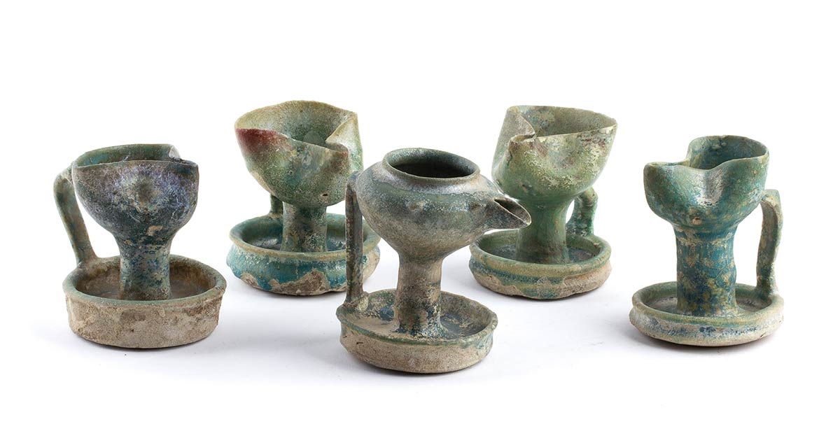 FIVE TURQUOISE-GLAZED HANDLED OIL LAMPSIran, Nishapur or Gurgan, 12th century