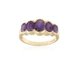 AN AMETHYST FIVE-STONE RING, composed of five graduated oval-shaped amethysts, mounted in 9K gold,