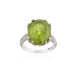 A PERIDOT AND DIAMOND DRESS RING, the oval mixed-cut peridot weighing approximately 8.50cts,