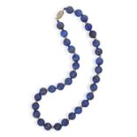 A LAPIS LAZULI BEAD NECKLACE, composed of round-shaped lapis lazuli beads measuring approximately