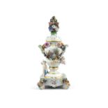 A MEISSEN PORCELAIN URN AND COVER ON STAND, of baluster shape, applied with cherubs, figures and