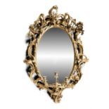 A LARGE GILTWOOD AND GESSO THREE BRANCH GIRANDOLE WALL MIRROR, 19th century, of oval form, the plain
