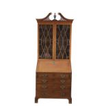 A GEORGE III MAHOGANY SLOPEFRONT BUREAU BOOKCASE, with broken swan neck pediment, above twin
