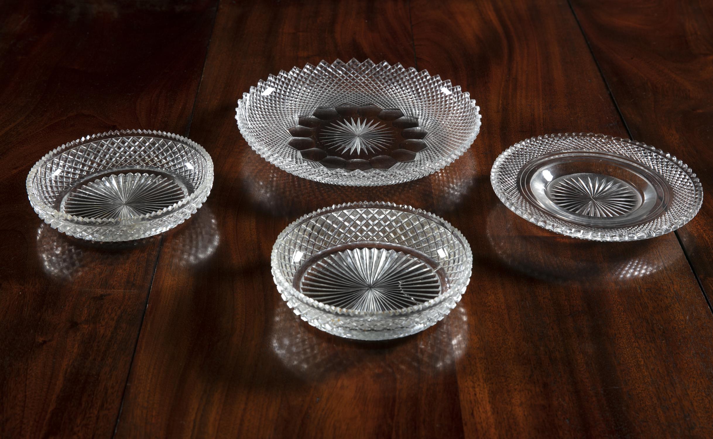A COLLECTION OF FOUR CUT GLASS DISHES, each of different sizes and variations of diamond cut and