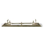 A LATE VICTORIAN CAST BRASS CURB FENDER, the rail with leaf and scroll ends having integrated