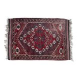 A TURKISH RED GROUND RUG, of rectangular shape woven with central medallion within a serrated