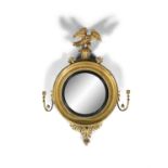 A EARLY 19TH CENTURY GILTWOOD CONVEX WALL MIRROR, of circular form, surmounted with a model of