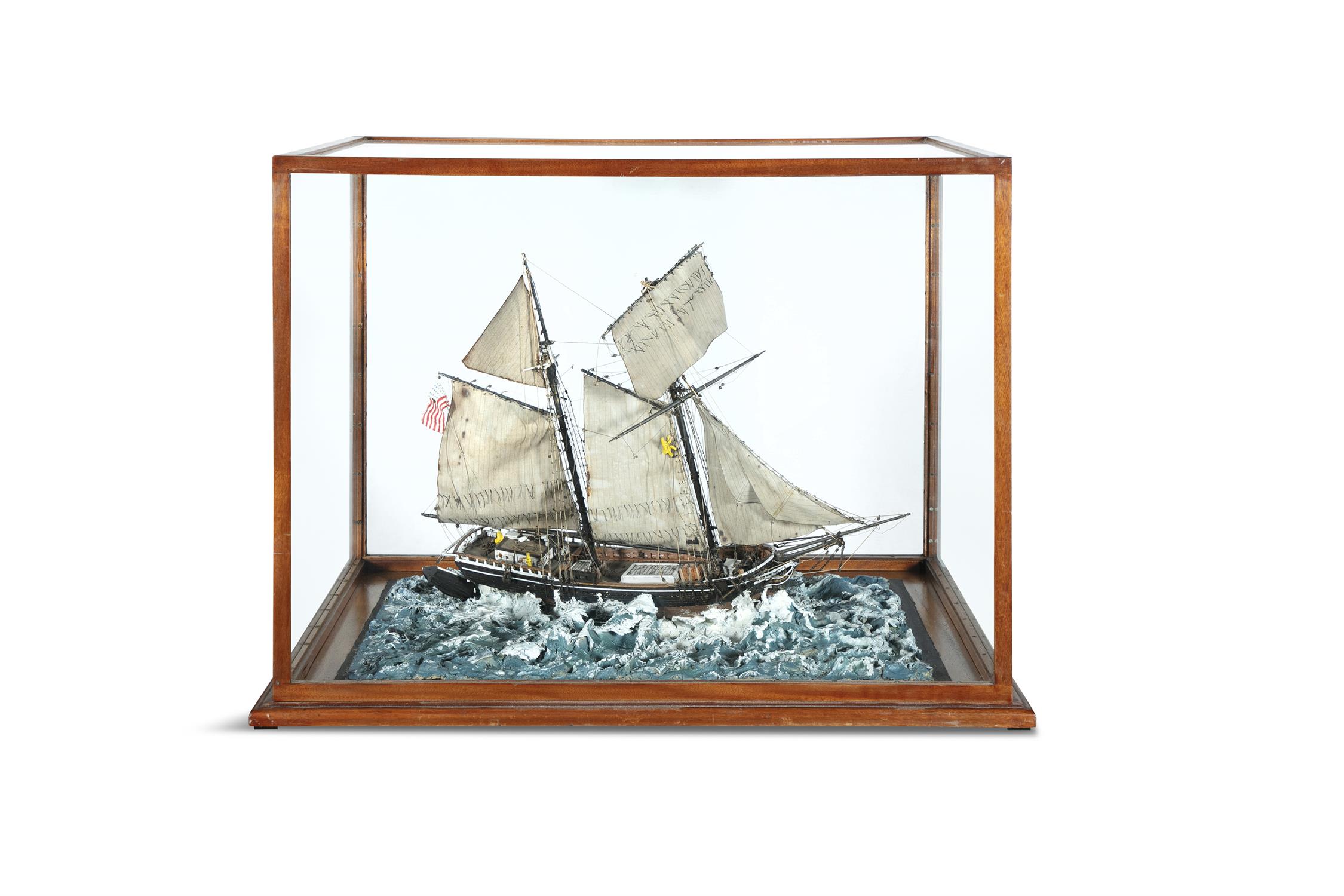 A 19TH CENTURY MODEL OF 'EAGLE' A TWO-MAST BOAT, in choppy waters and housed within a timber