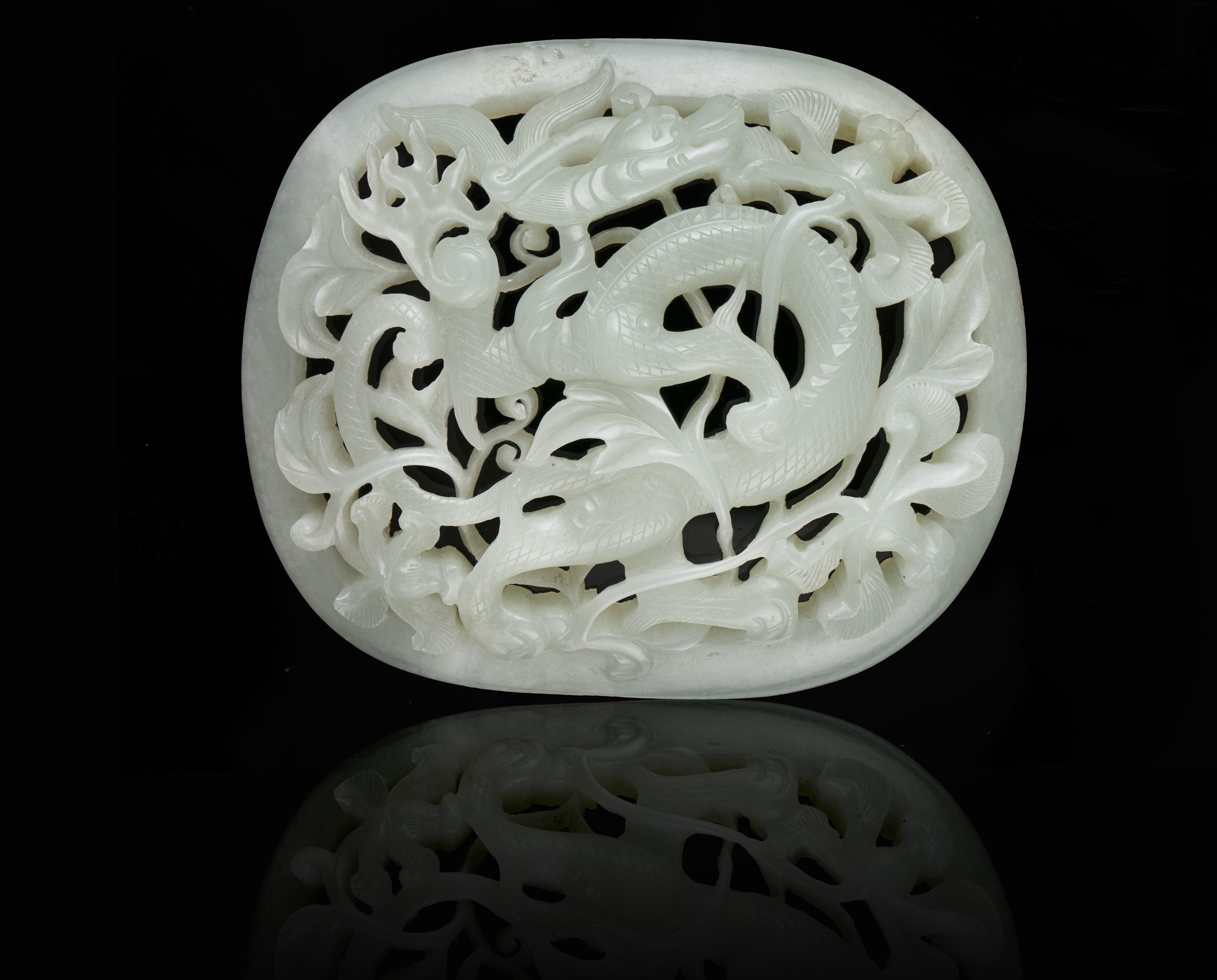 AN OPEN-WORKED WHITE JADE 'DRAGON' PLAQUE China, Antique, Possibly Ming Dynasty H: 7,8 cm - w: 9,2