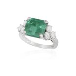 AN EMERALD AND DIAMOND DRESS RING The cut-cornered rectangular-cut emerald weighing