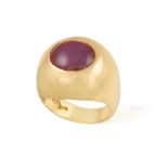 A RUBY AND DIAMOND RING Of bombé shape centering an oval-shaped ruby cabochon,