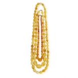 A GROUP OF THREE AMBER NECKLACES Each necklace composed of graduated amber beads,