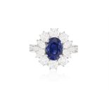 A SAPPHIRE AND DIAMOND CLUSTER RING The oval-shaped sapphire weighing approximately 2.