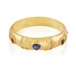 A SAPPHIRE, RUBY AND DIAMOND BANGLE The hinged bangle set with a heart-shaped sapphire at the