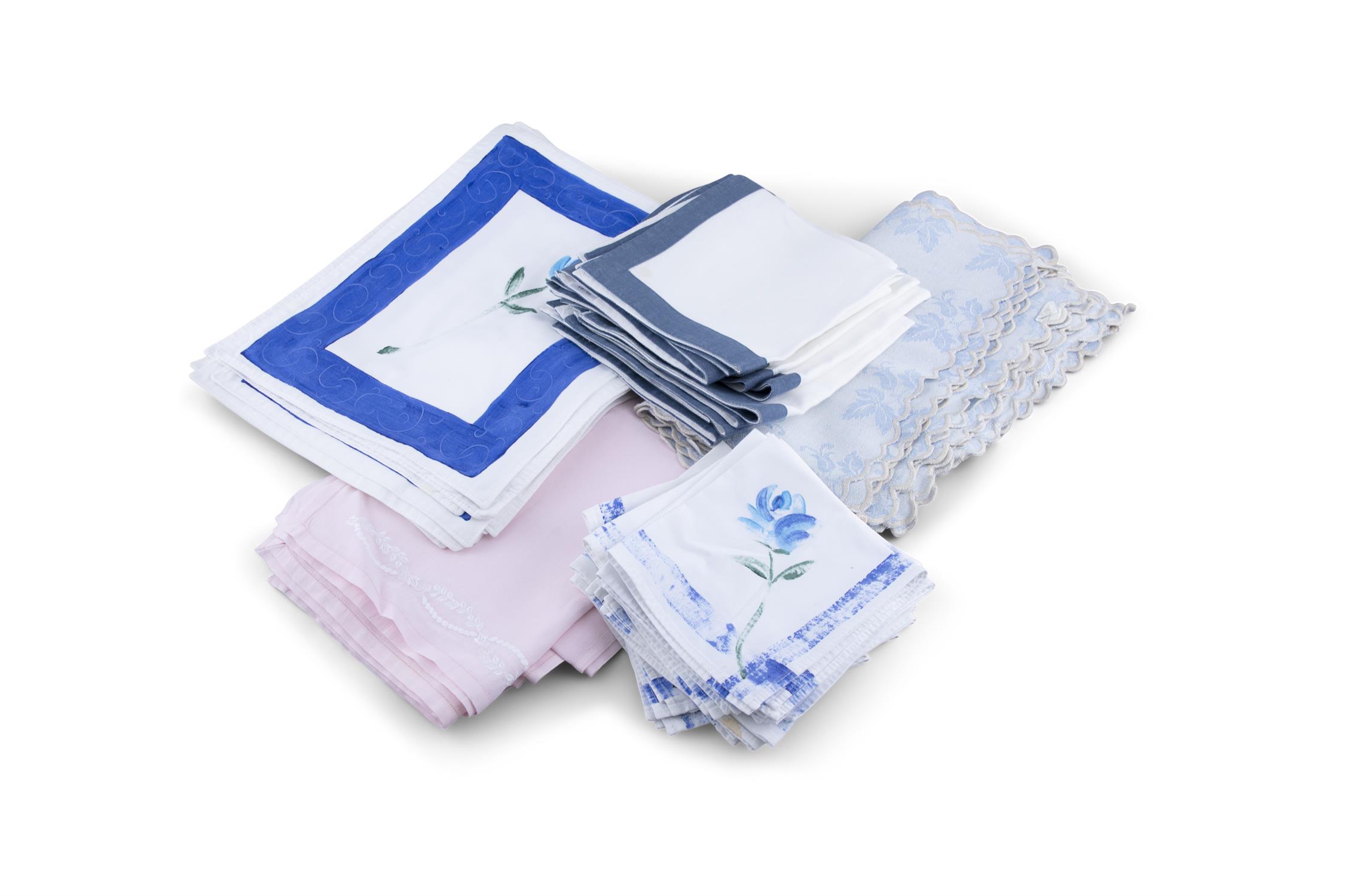 A COLLECTION OF BLUE AND WHITE TABLE LINENS, mats and matching napkins some with printed floral