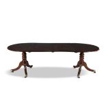A GEORGE III MAHOGANY D-END DINING TABLE, the top with moulded rim, raised on twin turned pillar