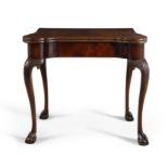 A GEORGE III MAHOGANY CARD TABLE, the folding top set with round candle stands and counterwells and