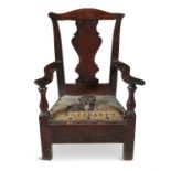 A SMALL PROVINICAL CHILD’S CHAIR, late 18th century with solid vase shape splat, drop in seat and