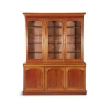 A VICTORIAN MAHOGANY THREE DOOR BOOKCASE, with moulded cornice above plain arched top glazed panel