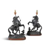 AFTER GUILLAUME COUSTOU (1677-1746) A pair of black patinated metal models of Marly Horses with