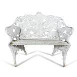 A WHITE PAINTED CAST IRON GARDEN SEAT, of compact two-seater proportion with fern pattern back and
