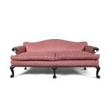 AN IRISH GEORGE III MAHOGANY FRAMED HUMPBACK SETTEE, upholstered in pink fabric, with carved