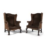 A MATCHED PAIR OF GEORGIAN STYLE MAHOGANY FRAMED WING BACK ARMCHAIRS, covered in brown velvet and