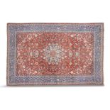 A NORTH WEST PERSIAN MESHED CARPET, woven in red and sky blue tones, the large central field with a