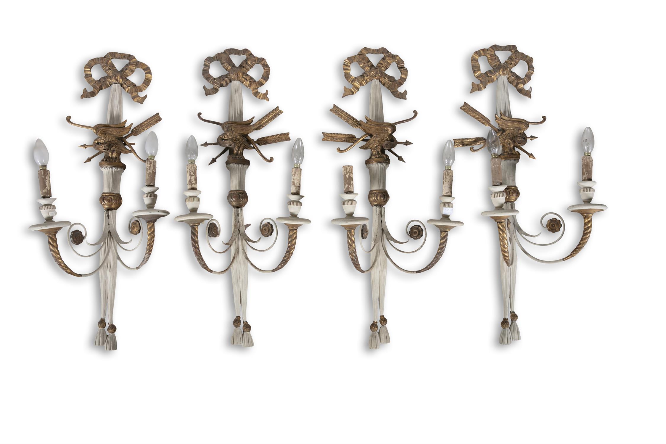 A SET OF FOUR REGENCY STYLE CREAM PAINTED AND GILT TWO-LIGHT WALL SCONCES, with tied ribbons,