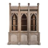 A VICTORIAN BLEACHED OAK GOTHIC BOOKCASE, the high castellated cornice and pierced arcading above