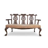 A GEORGE III MAHOGANY FRAMED TRIPLE CHAIR BACK SETTEE, the curved crest rails above pierced ribbon