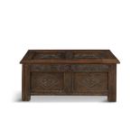 A CHARLES I OAK COFFER, c.1640, of rectangular shape, the hinged cover carved with a pair of