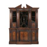 A MAHOGANY BREAKFRONT BOOKCASE, following a design by William Kent, surmounted by an architectural