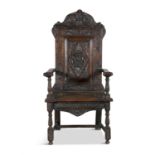 A 17TH CENTURY CARVED OAK WAINSCOT CHAIR, the arched rectangular back carved with rosettes,