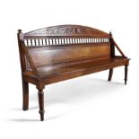 A VICTORIAN LONG BENCH by JAMES SHOOLBRED, the arched panel back with spindle gallery,