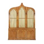 A VICTORIAN GOLDEN STAINED BEECH BOOKCASE IN THE GOTHIC TASTE, the lancet arch-top cornice above