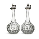 A PAIR OF CUT GLASS DECANTERS WITH MILLAR’S PATENT HINGED COVERS,. 31cm high (2)