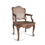 A FRENCH RÉGENCE PERIOD CARVED BEECHWOOD OPEN ARMCHAIR, the shaped rectangular back with carved