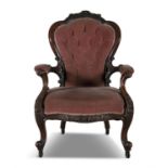 A VICTORIAN MAHOGANY FRAMED UPHOLSTERED BUTTON BACK ARMCHAIR, with arched padded back and stuffed